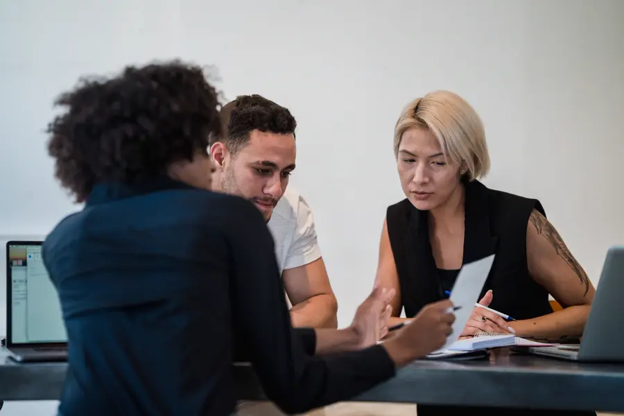 Equipe revisando documentos de uma operação em uma mesa de reunião